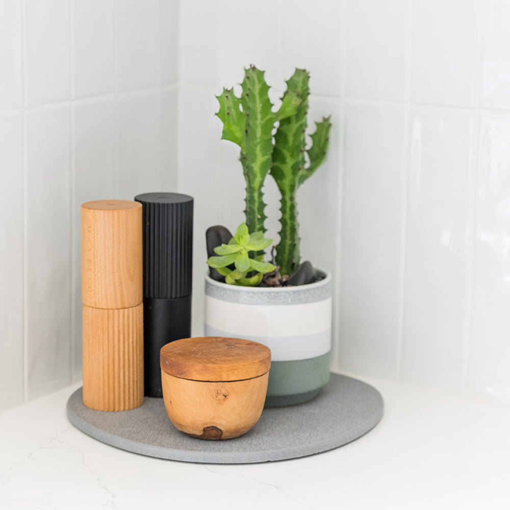 kitchen corner with pepper and salt grinders on top of stone saucer 